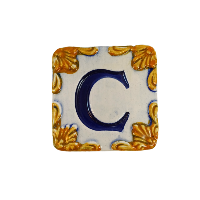 Azulejo quadrado com letra C azul e ornamentos dourados