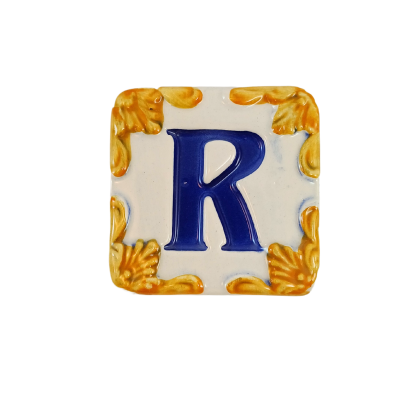 Azulejo quadrado cerâmico com letra R azul e detalhes dourados nos cantos