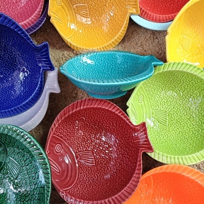 Pratos de cerâmica coloridos em forma de peixe com textura de escamas