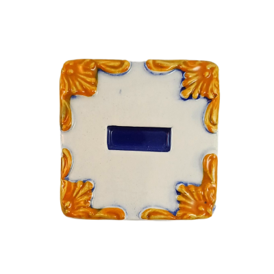 azulejo quadrado branco com detalhes dourados nos cantos e retângulo azul ao centro