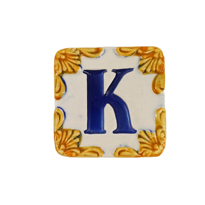 Azulejo cerâmico quadrado com a letra K azul e moldura amarela