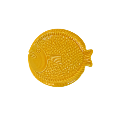 Prato amarelo em forma de peixe em fundo branco