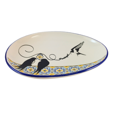 Prato oval de cerâmica com padrão amarelo e azul e desenho de pássaros pretos