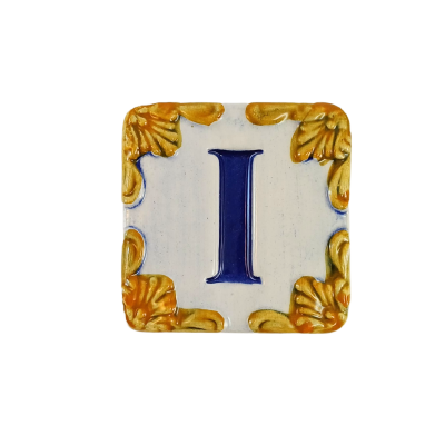Azulejo cerâmico quadrado decorado com letra 'I' azul e cantos amarelos