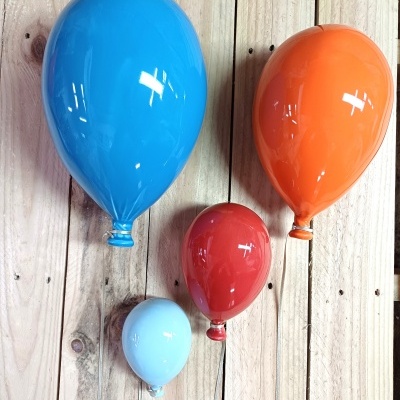 Quatro balões coloridos de látex numa parede de madeira