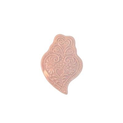 Barra de sabão rosa claro com padrão decorativo em relevo