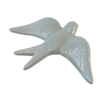 Figura decorativa em cerâmica branca em forma de pássaro com asas abertas