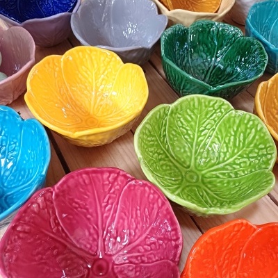 Taças coloridas em forma de folhas com textura, dispostas em madeira