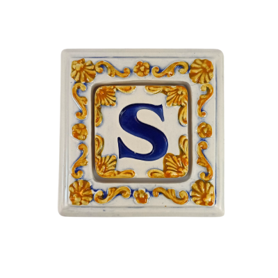 Azulejo cerâmico quadrado com letra S azul e decoração dourada