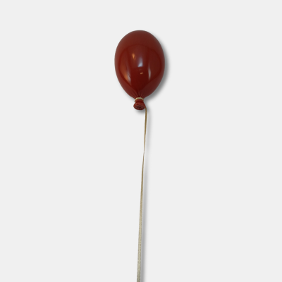 Balão vermelho com cordão branco contra fundo branco
