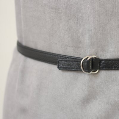 Cinto fino preto em pele com fivela dupla prateada ajustado em tecido cinzento claro