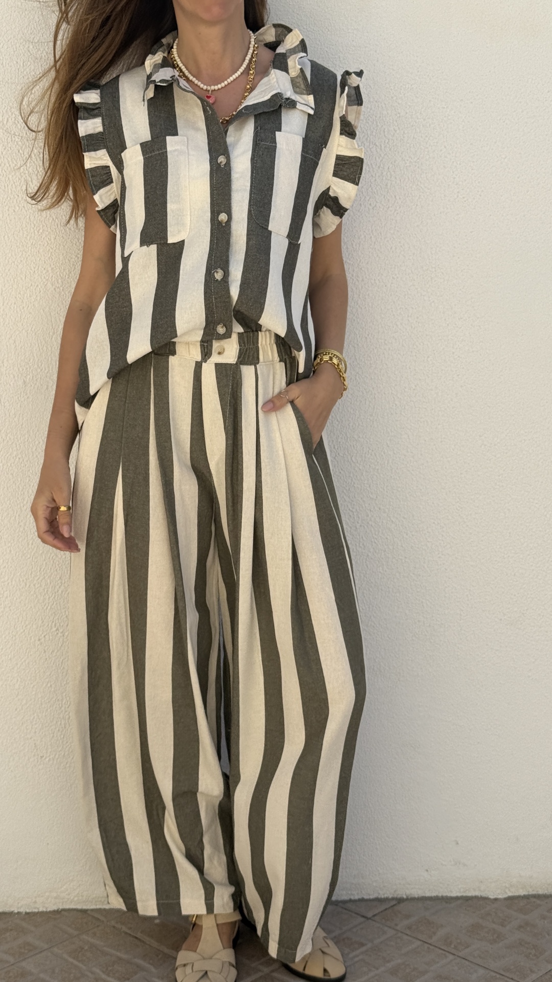 Conjunto feminino riscas preto e branco com camisa sem mangas e calças largas.