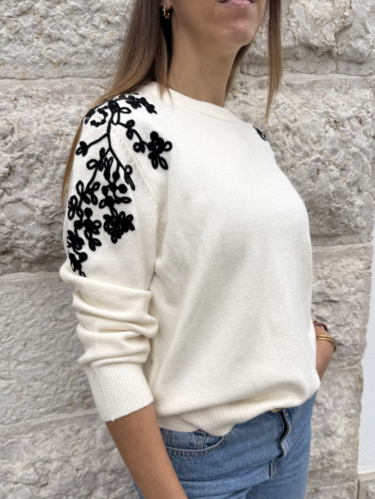 Camisola creme de malha com flores pretas bordadas nos ombros e manga comprida