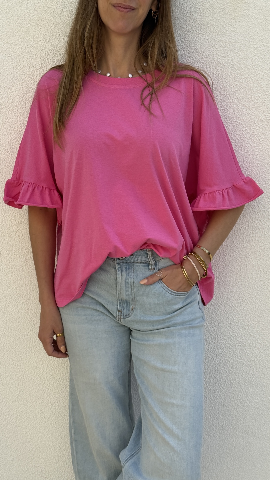 T-shirt rosa com folhos nas mangas e calças de ganga claras