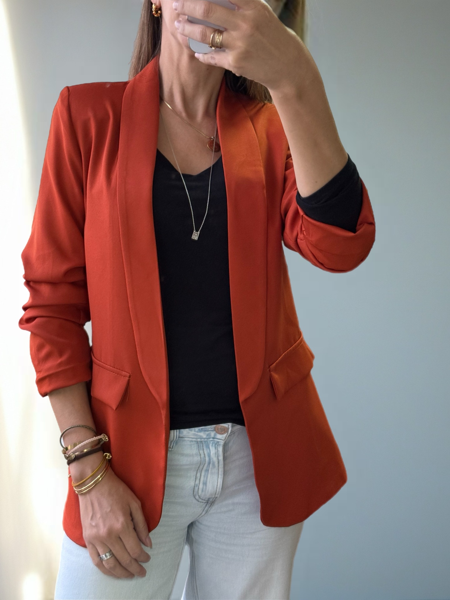 Blazer feminino laranja com camiseta preta e jeans claros