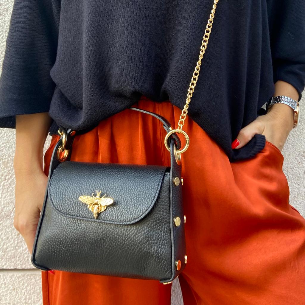 Mala preta de pele com fecho dourado de abelha e alça de corrente dourada
