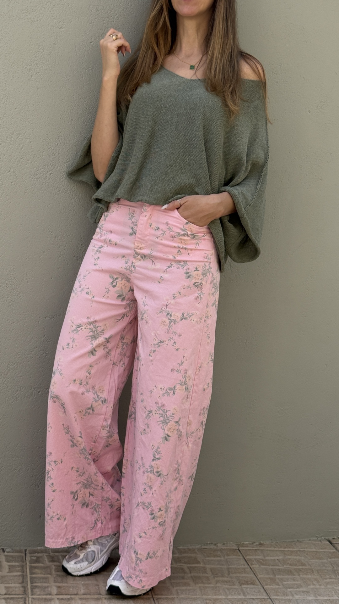 Calças largas rosa com padrão floral e blusa verde musgo de malha