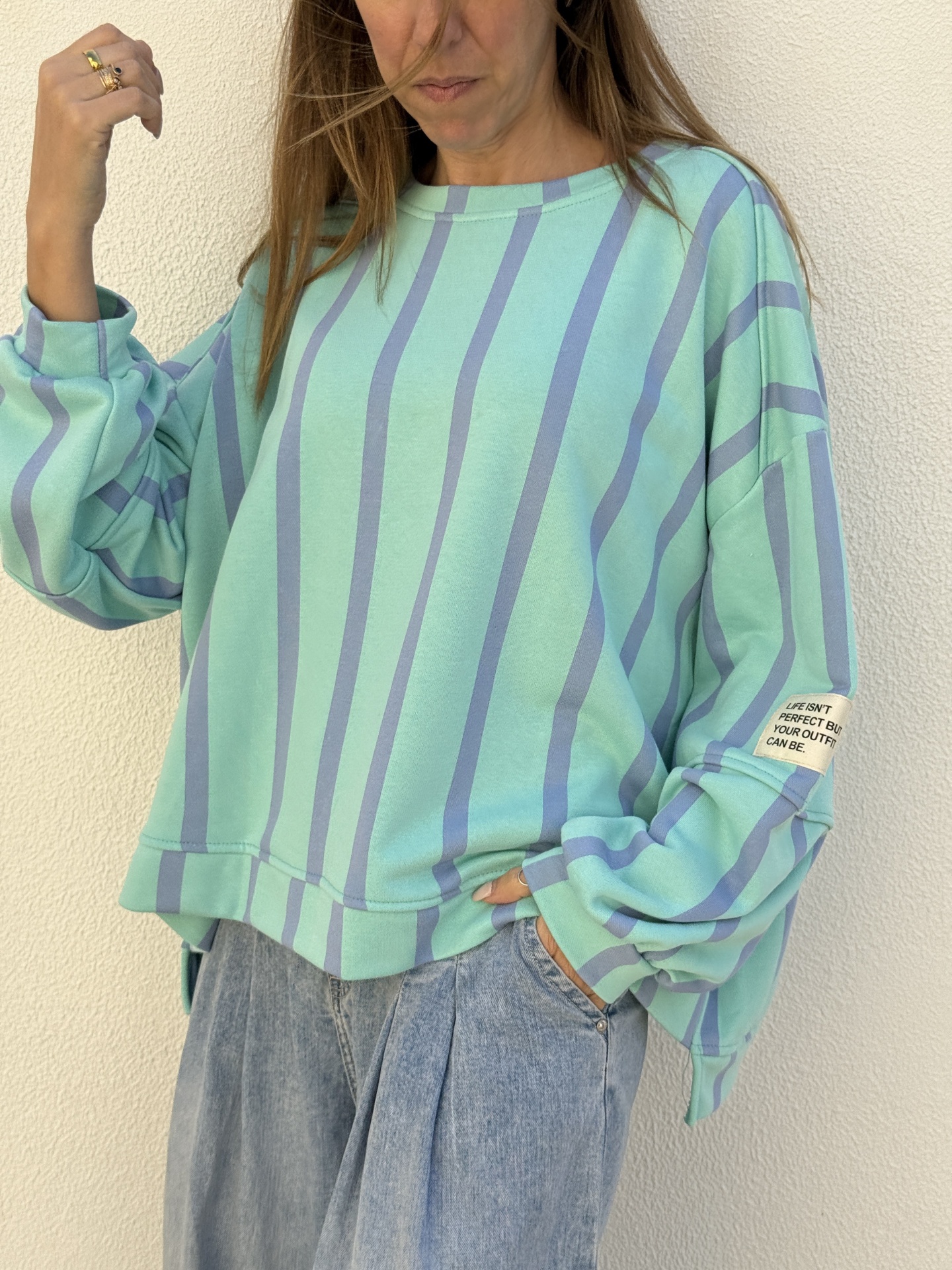 Sweatshirt riscada verde-água e azul com etiqueta na manga