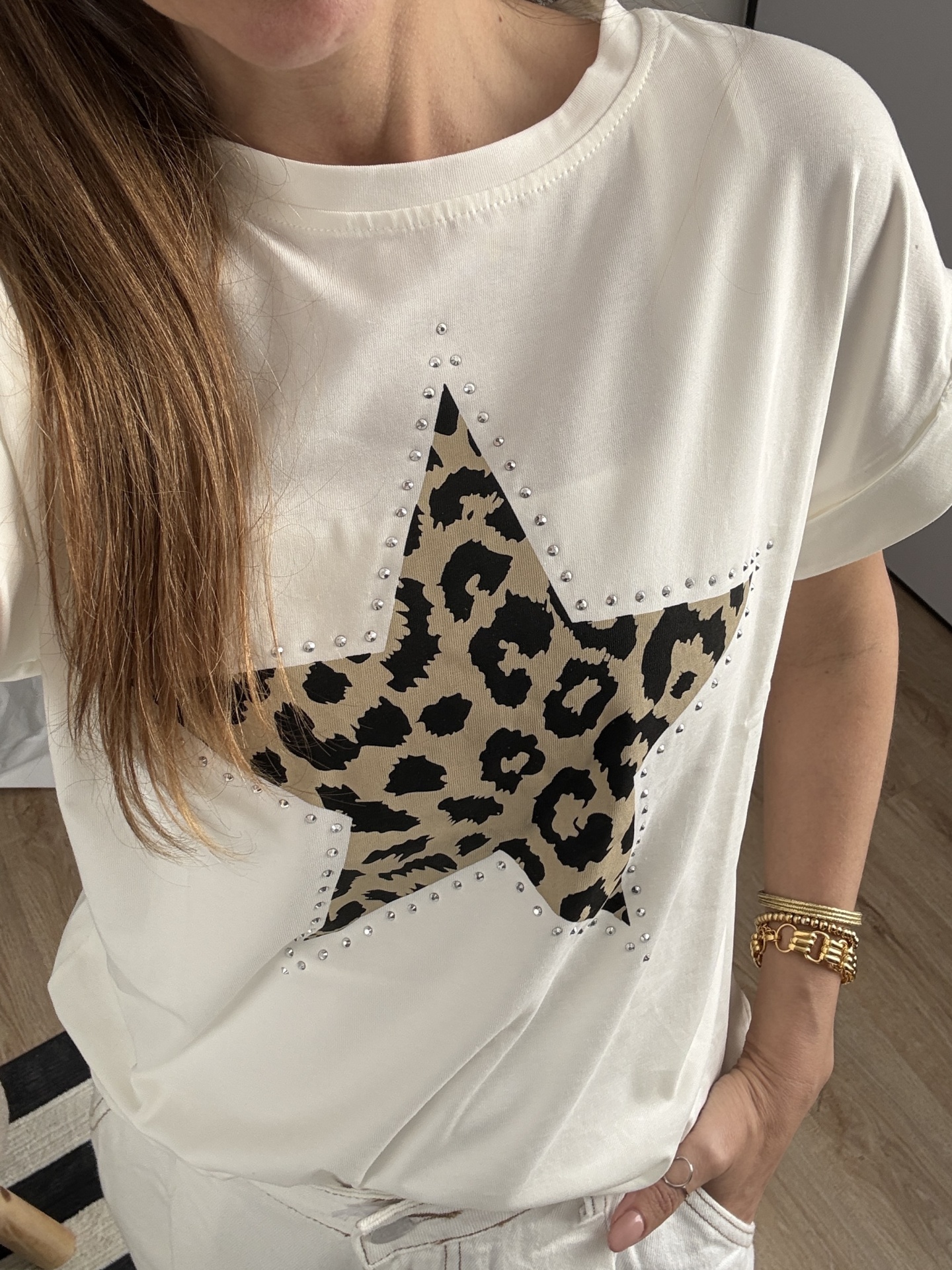 T-shirt branca com estrela em padrão animal print e tachas prateadas.