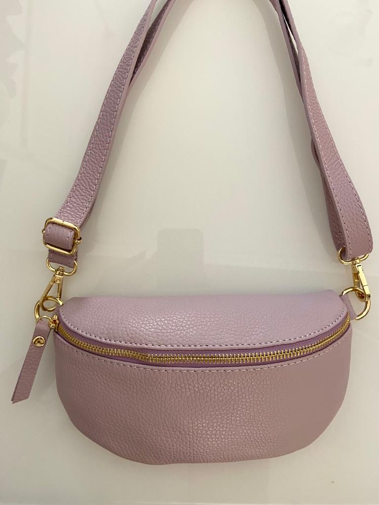 Bolsa rosa claro com zip dourado e alça ajustável sobre fundo branco