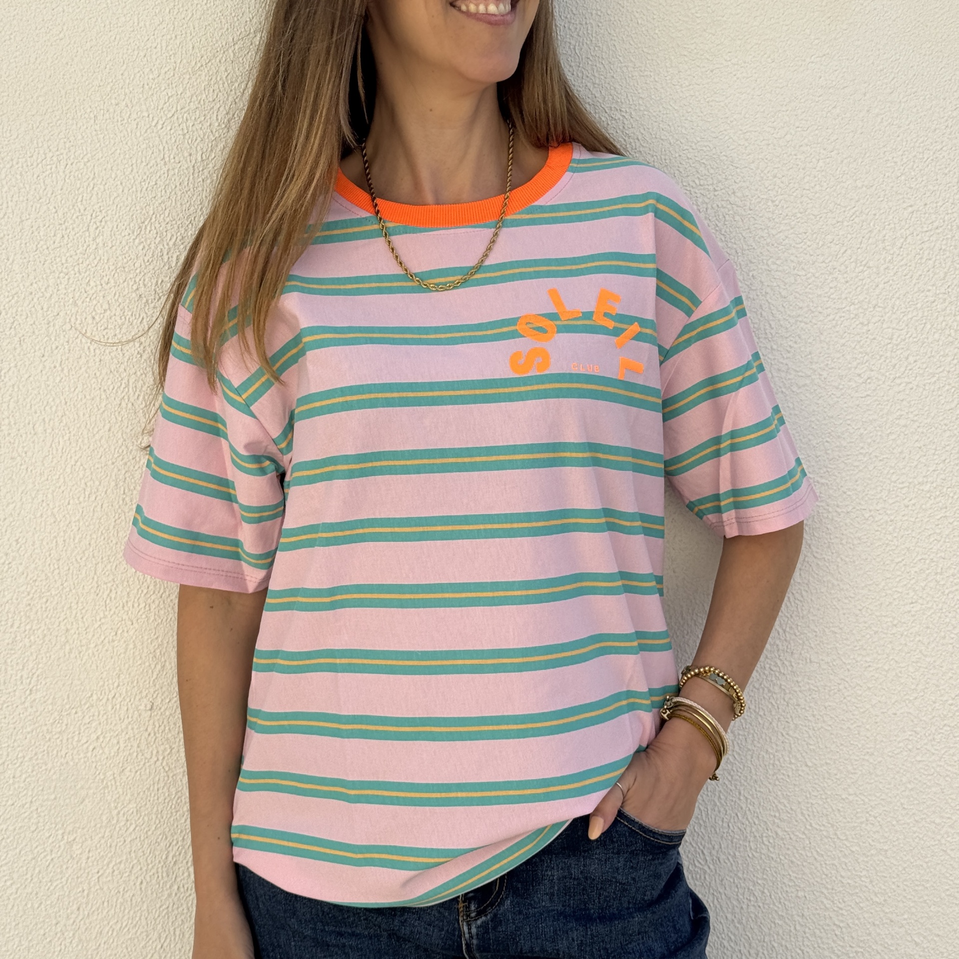 T-shirt rosa às riscas verdes e amarelas com gola laranja e texto SOLEIL CLUB