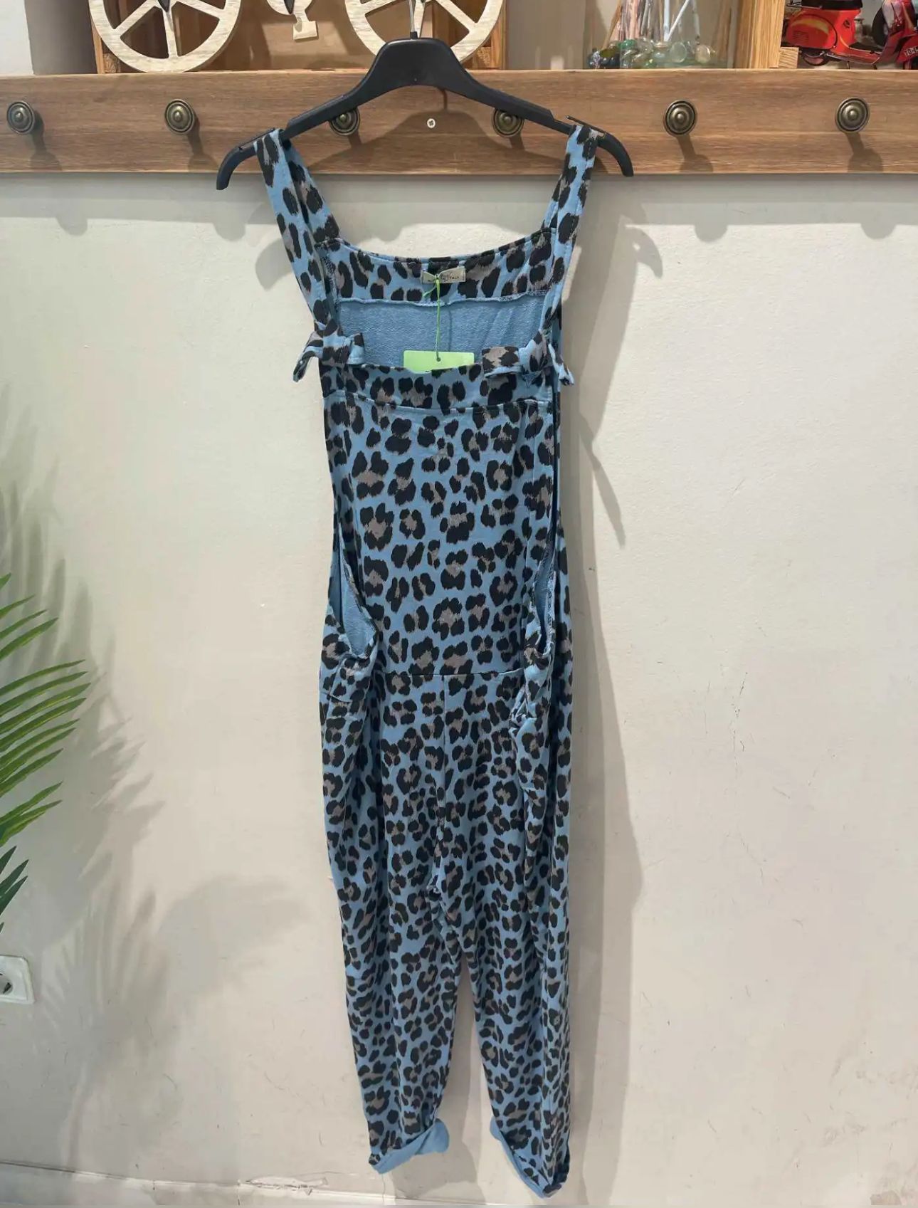 Macacão azul com padrão de manchas pretas pendurado num cabide