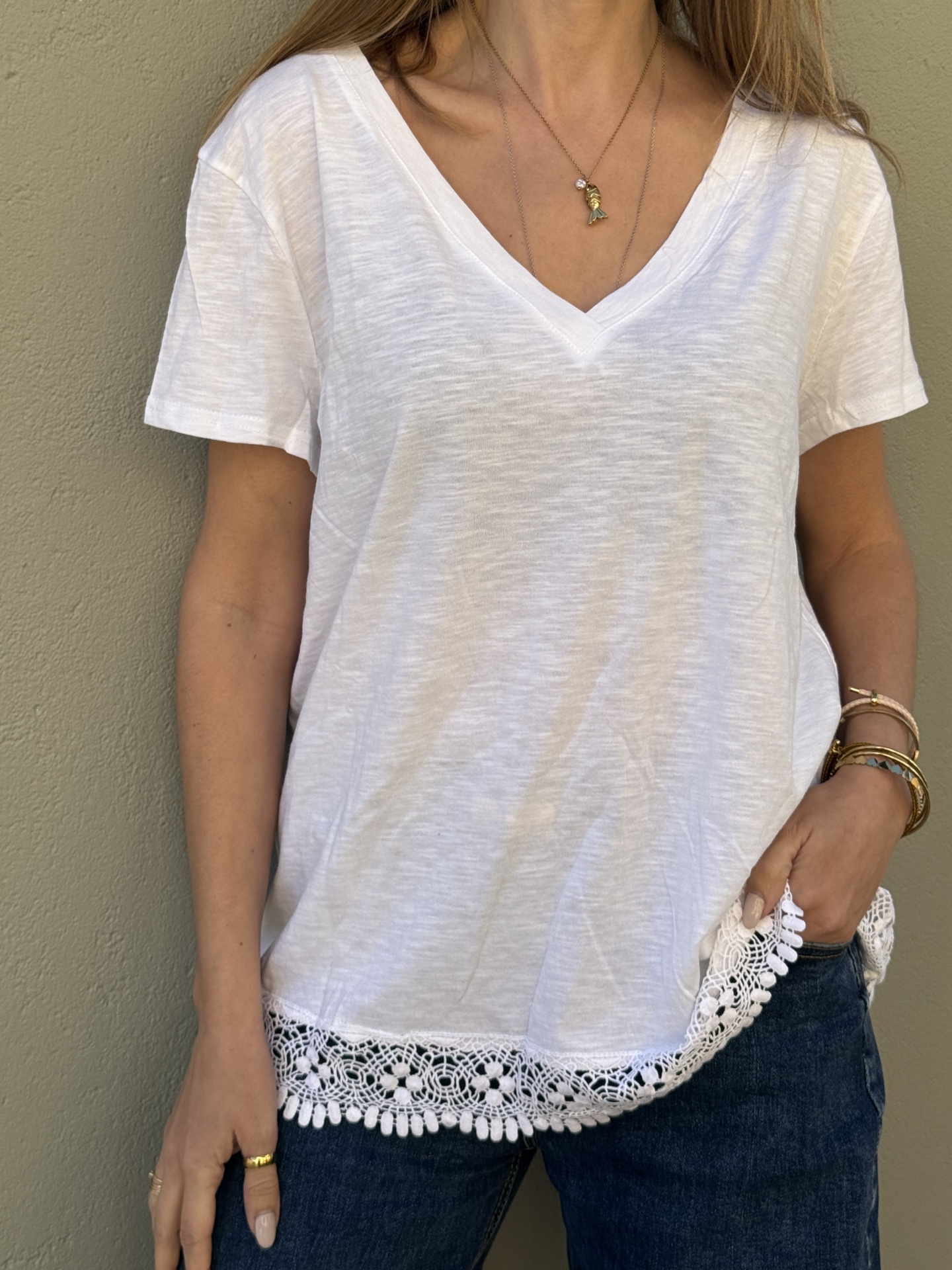 T-shirt branca feminina com barra em renda e jeans azul escuro