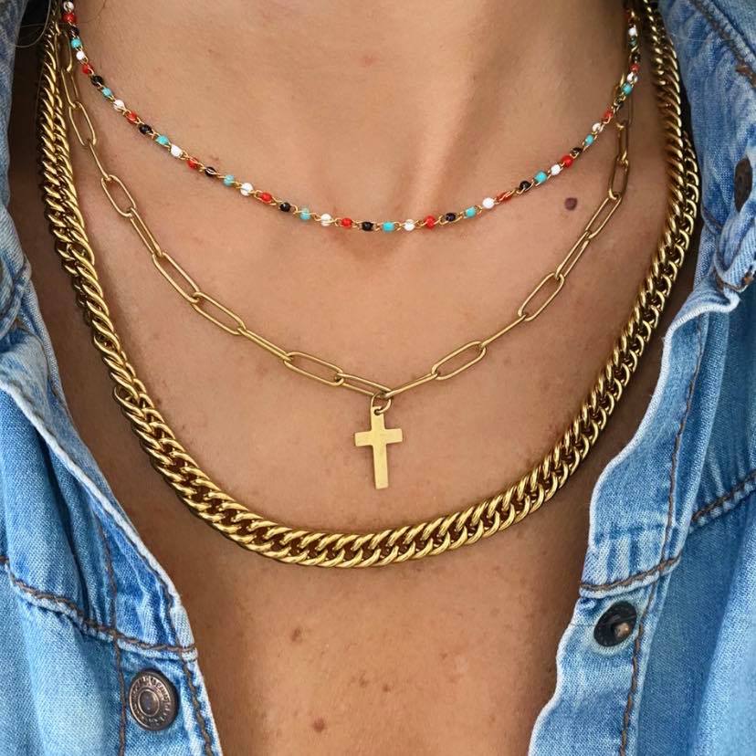 colar triplo com correntes douradas e contas coloridas sobre camisa jeans azul claro