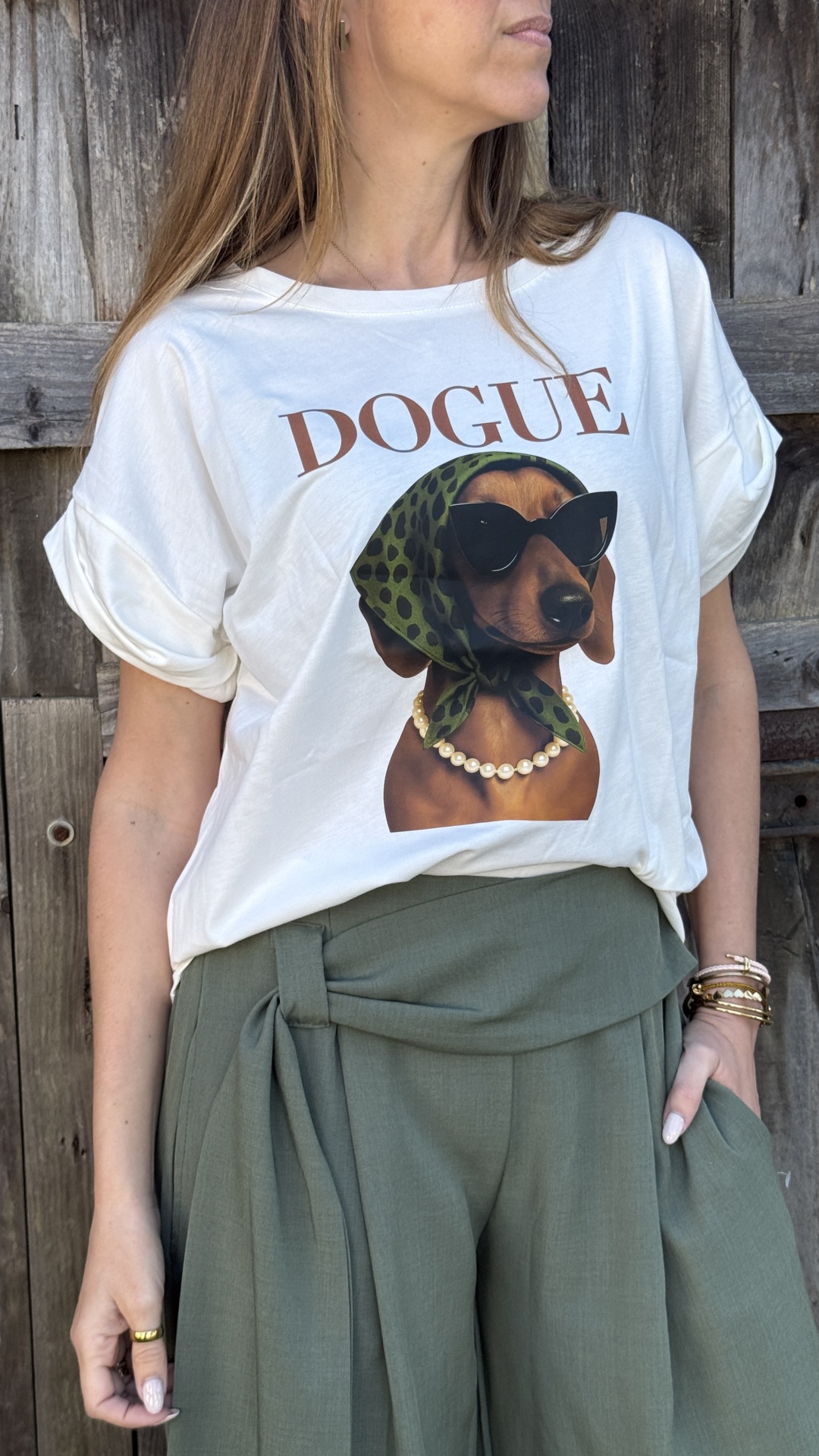 T-shirt branca com estampa de cão com lenço verde, colar de pérolas e óculos escuros, calças verdes largadas