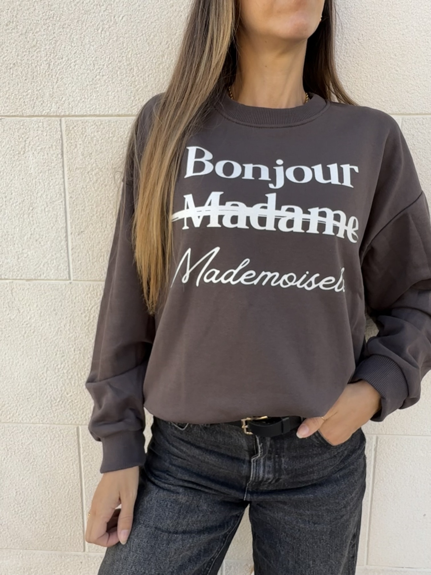 Sweatshirt castanha escura com texto branco usada por mulher