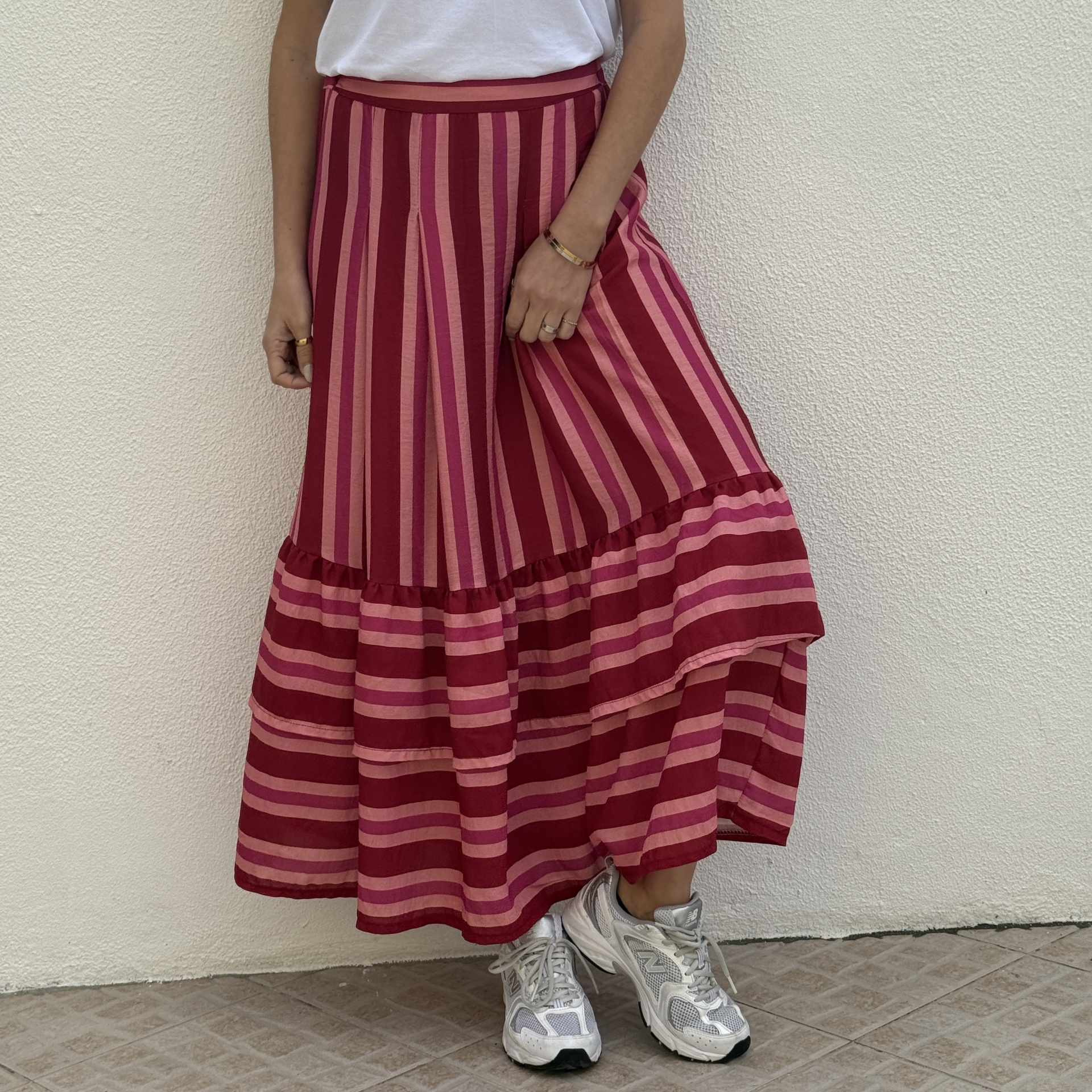 Saia comprida com riscas vermelhas e rosas e ténis brancos