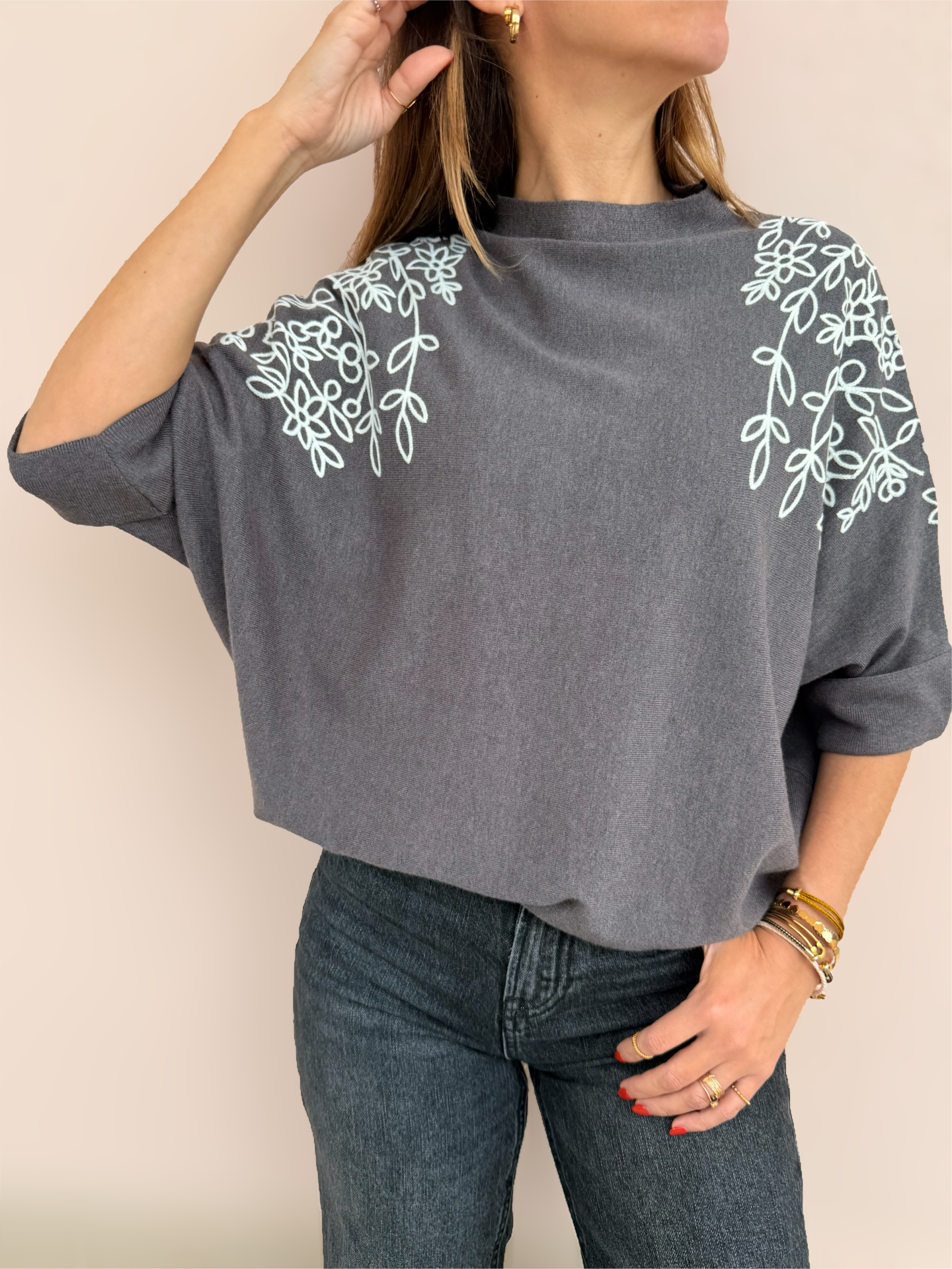 Casaco cinzento com padrão floral branco e jeans escuros