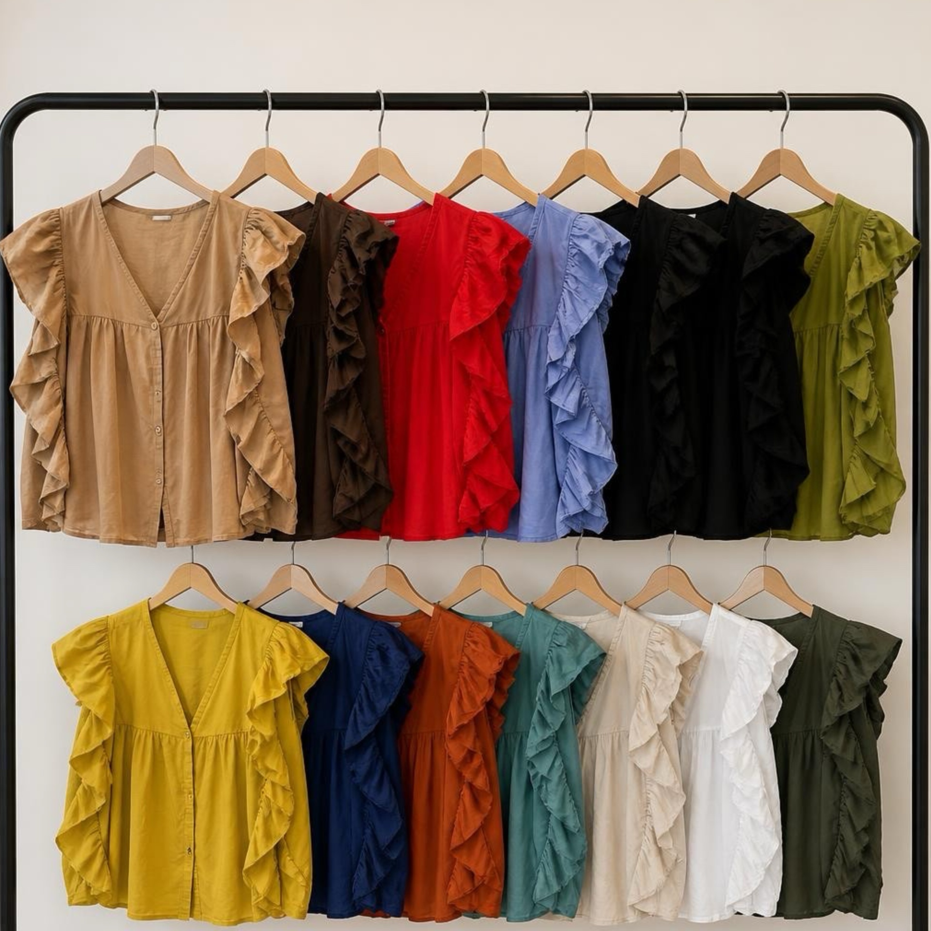 Blusas de manga folhada variadas em várias cores penduradas em cabides numa estrutura preta