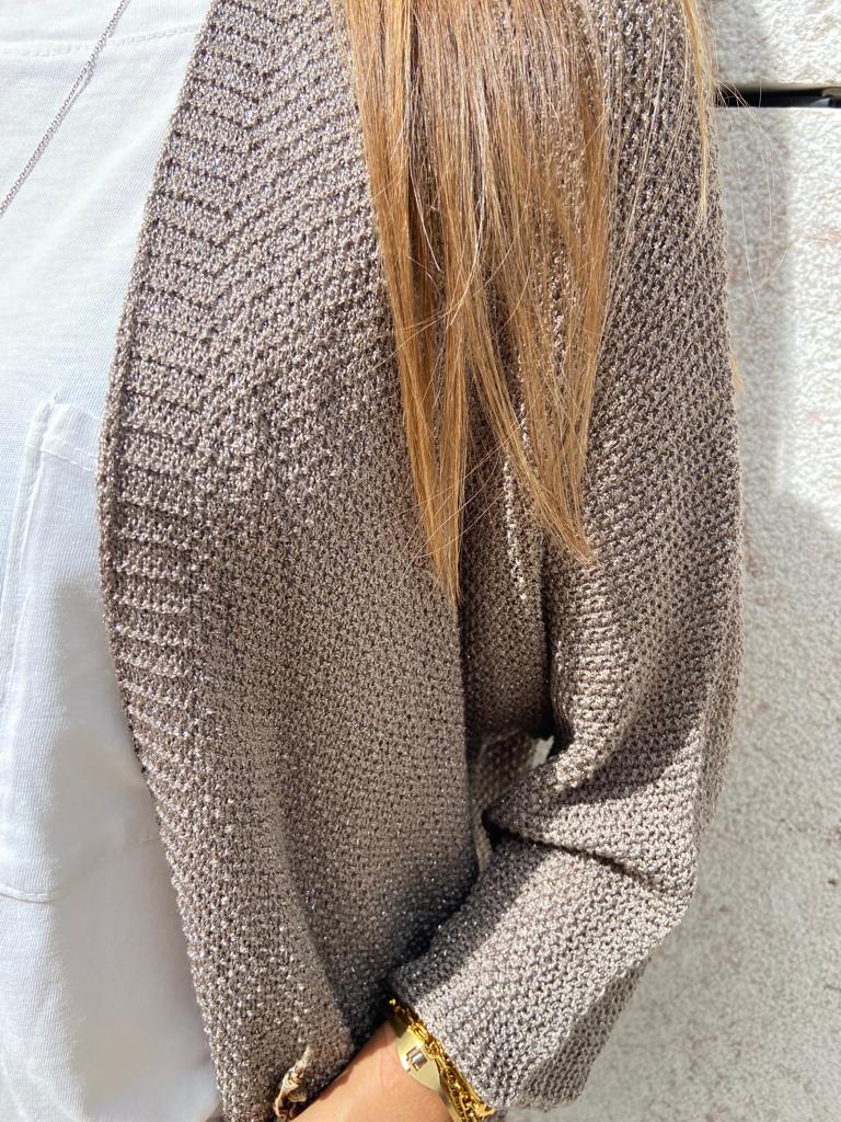 Casaco de malha cinza texturizada com padrão em relevo e decote em V sobre camisola branca.