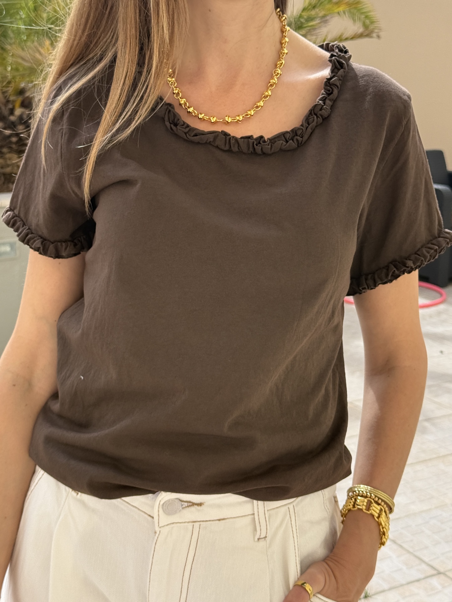T-shirt castanha com gola e mangas franzidas e acessórios dourados