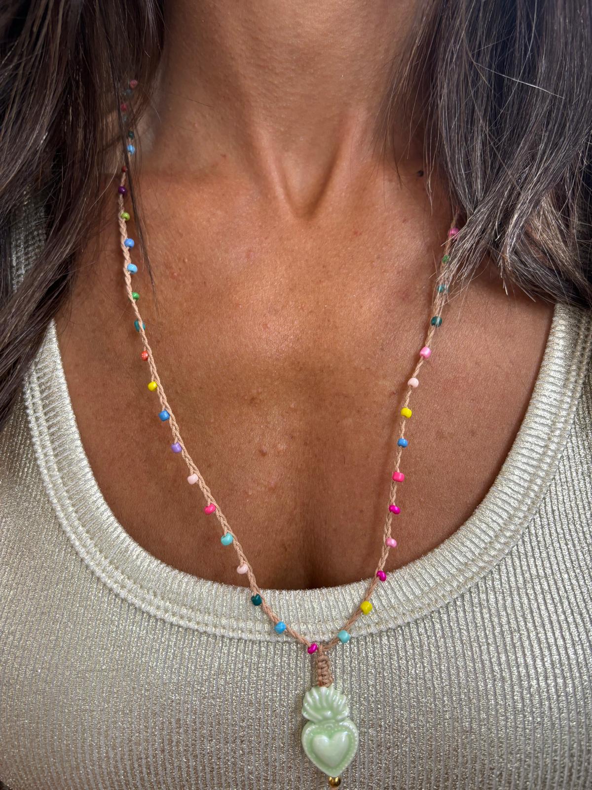 Colar com pendente em forma de coração verde claro e cordão com pompons coloridos