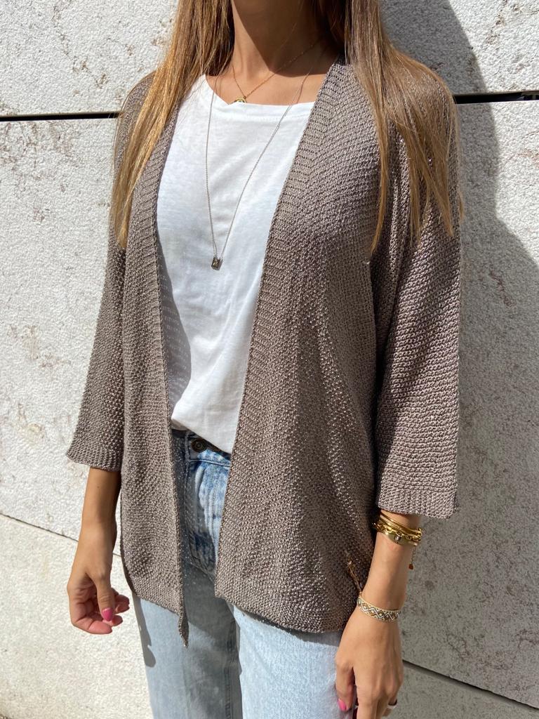 Casaco bege de malha com t-shirt branca e jeans azuis