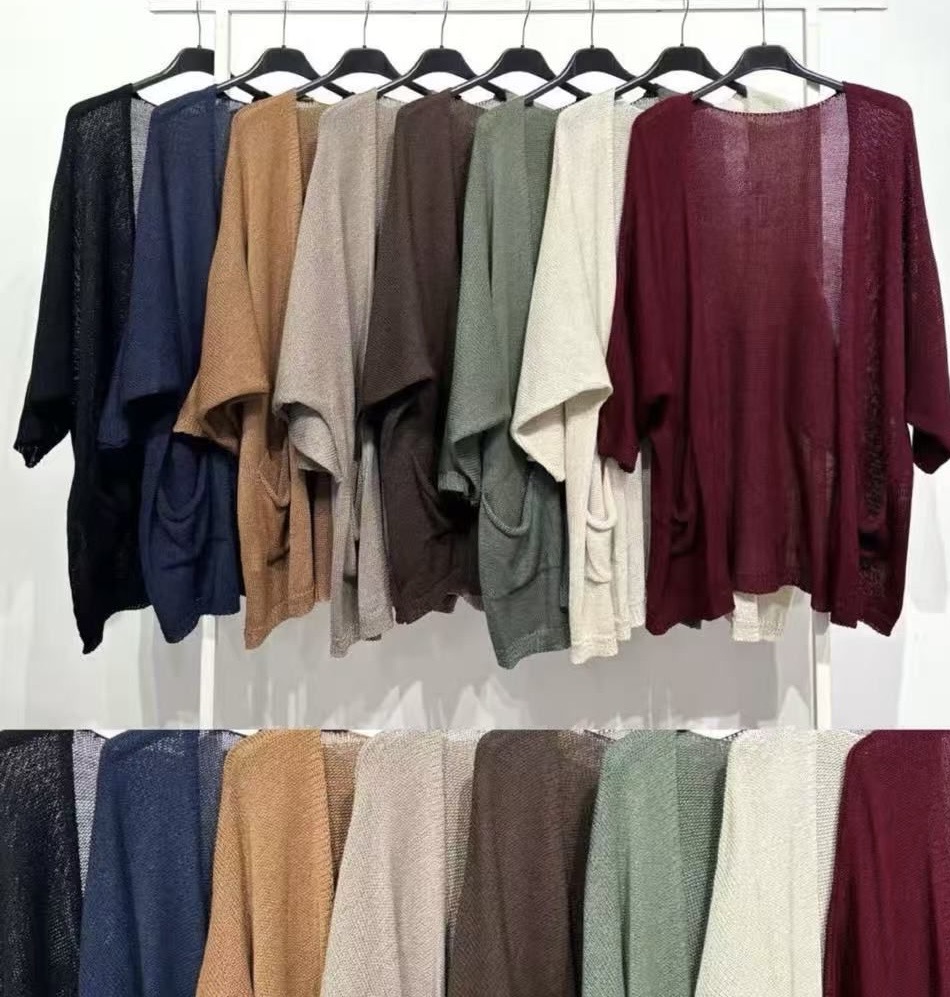 Oito casacos de malha de várias cores pendurados num cabide