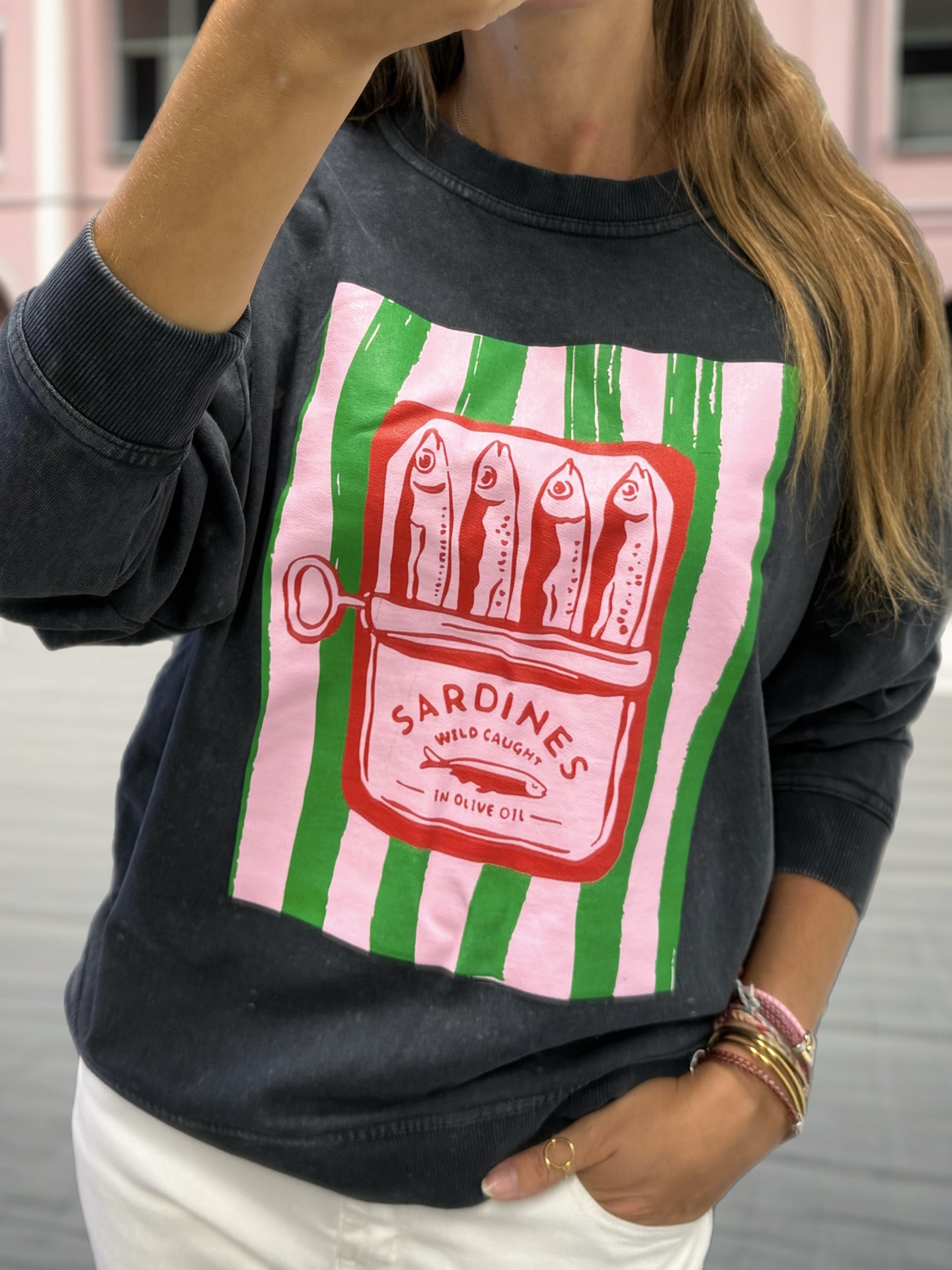 sweatshirt preta com estampa colorida de lata de sardinhas em riscas verdes e brancas