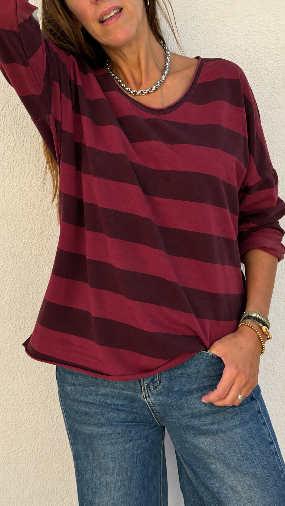Blusa de riscas horizontais vermelhas e vinho com calças de ganga e acessórios