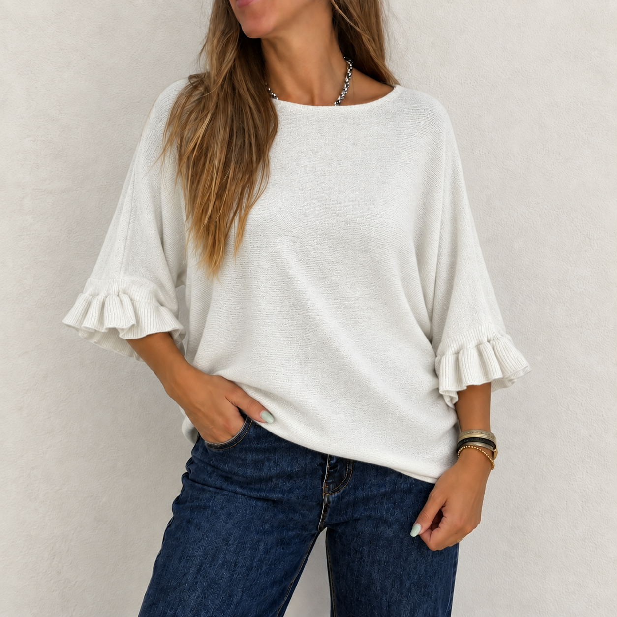 Camisola branca de manga 3/4 com folhos nas mangas combinada com calças jeans azul escuro