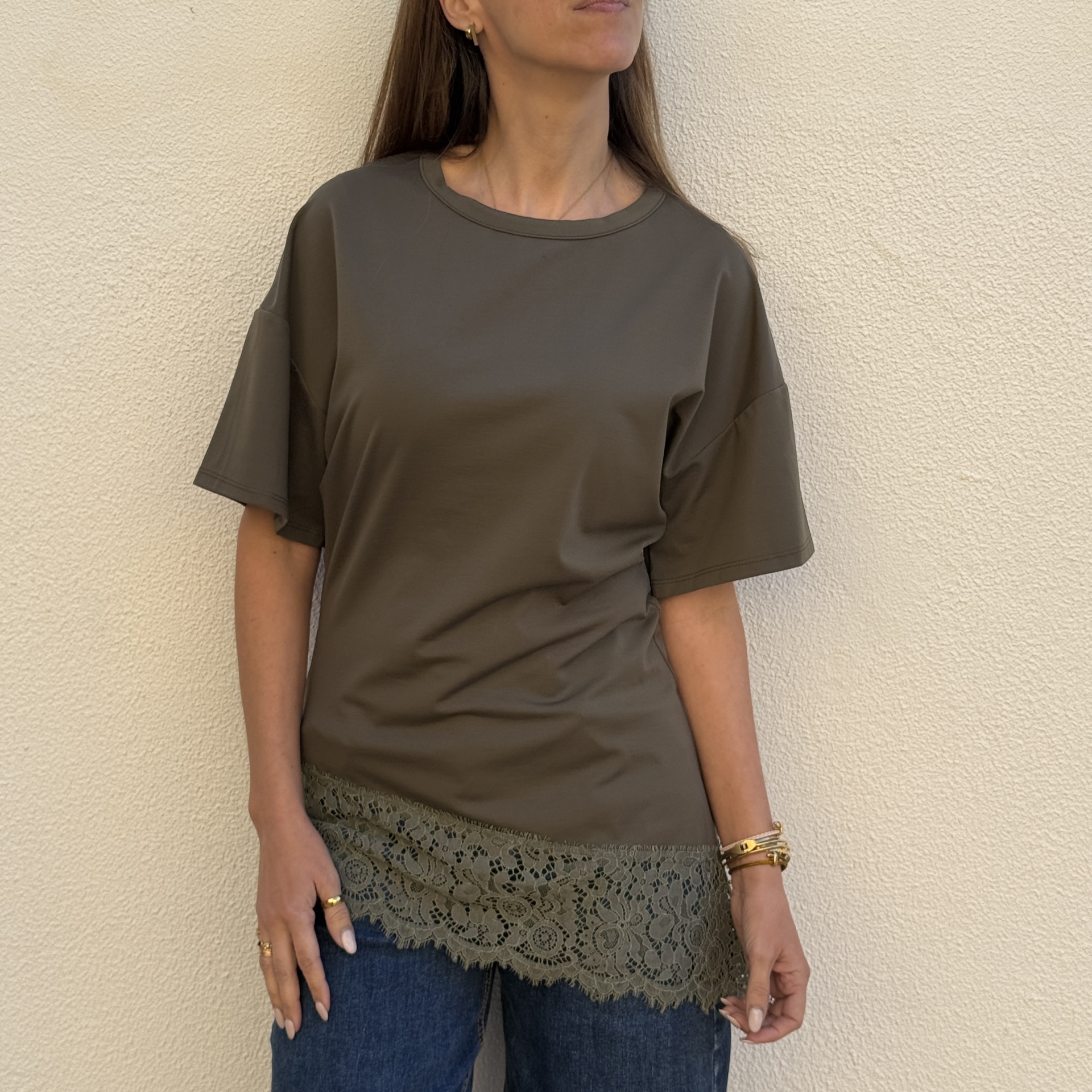 T-shirt verde caqui com renda na parte inferior usada por mulher
