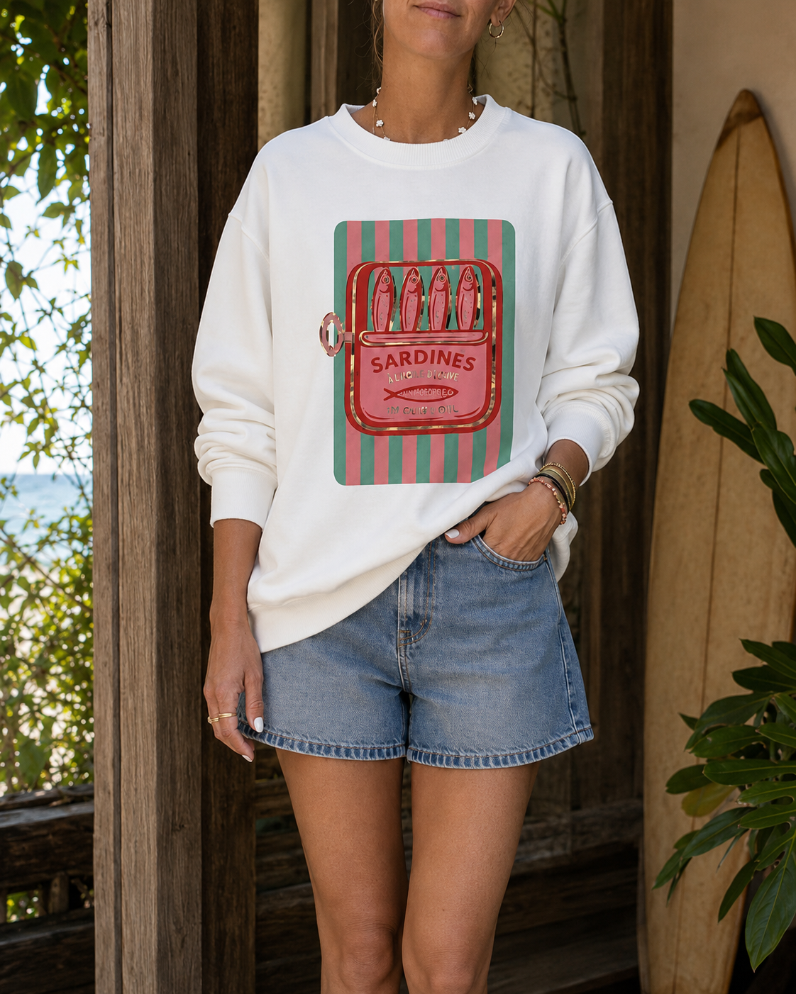 Sweatshirt branca com imagem de lata de sardinhas vermelha e verde e calções de ganga