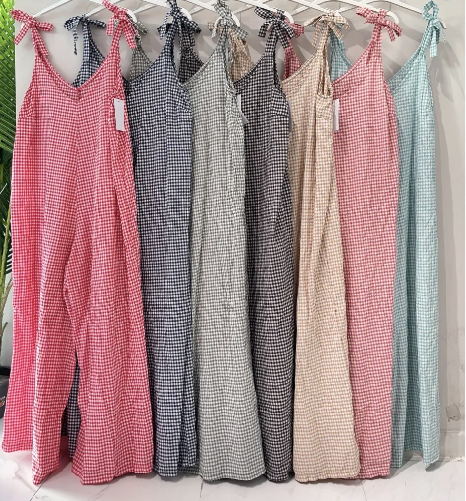 Vestidos compridos com padrão aos quadrados pequenos em várias cores pendurados numa estrutura branca