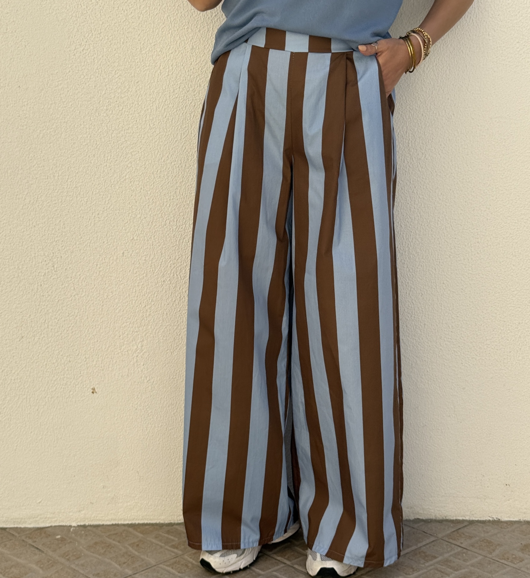 Calças compridas riscas verticais azuis claras e castanhas