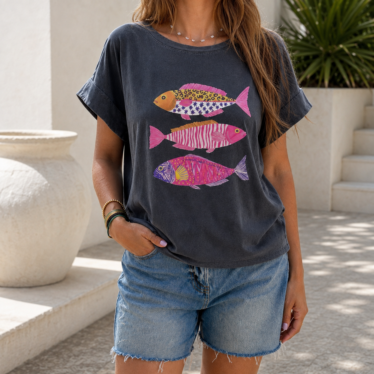 T-shirt cinza escuro com três peixes coloridos estampados na frente e calções de ganga azul claro.