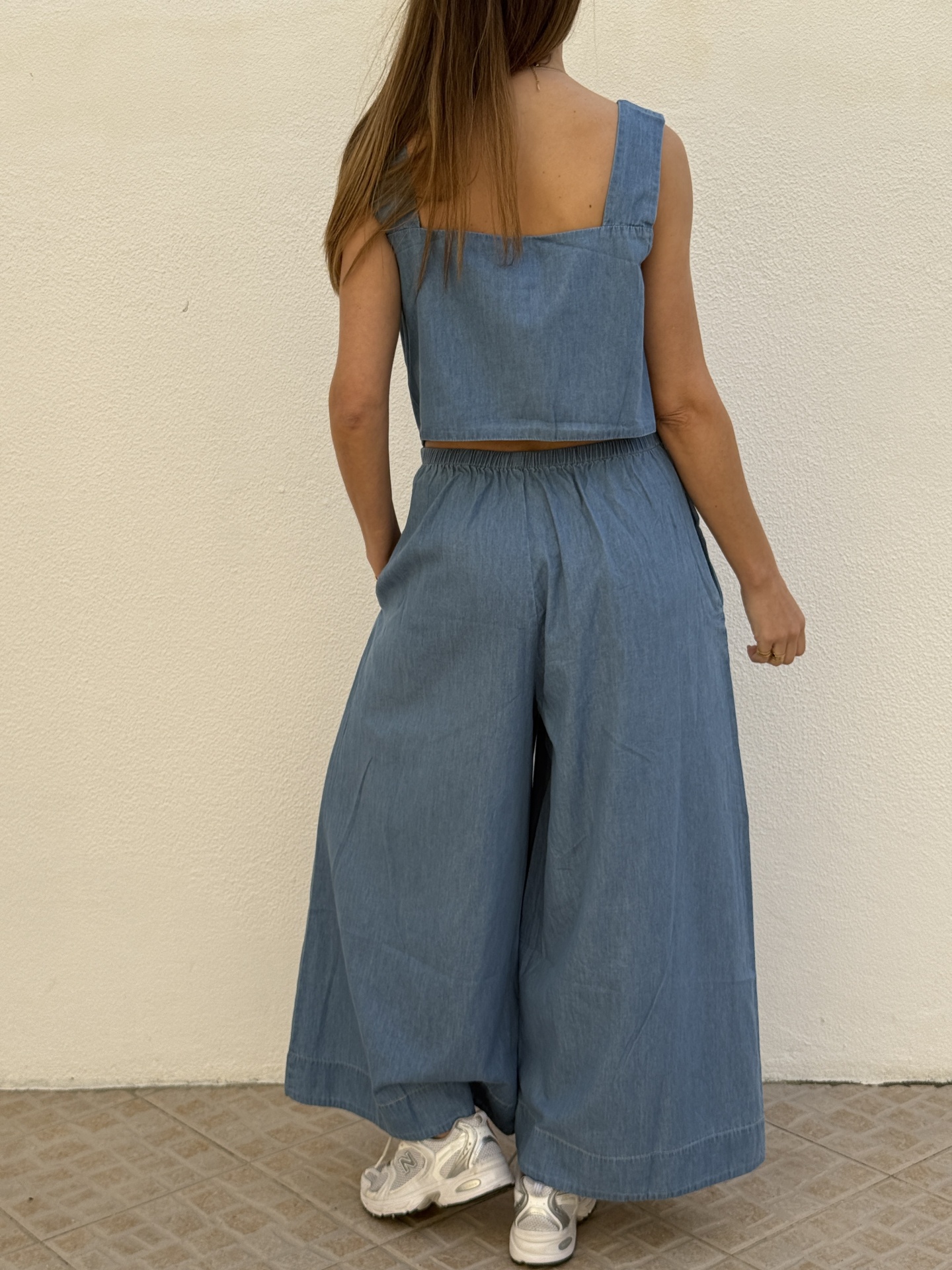 Conjunto azul denim com top e calças largas e ténis brancos