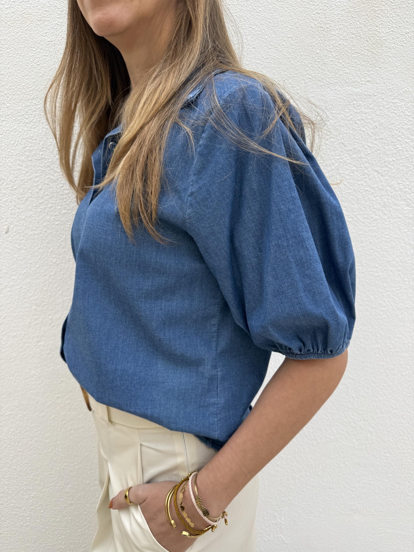 Blusa azul denim com mangas curtas bufantes e calças brancas