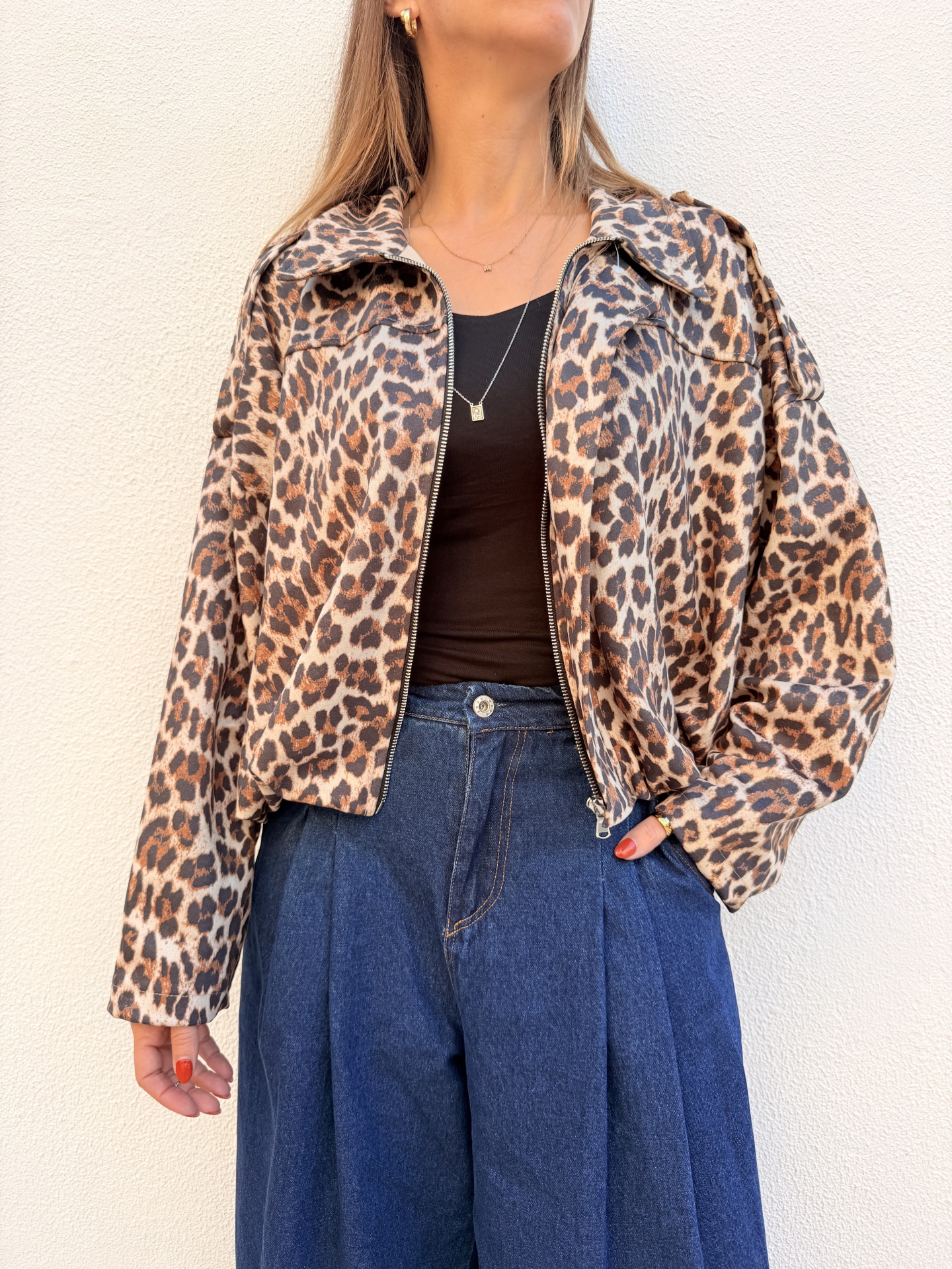 Casaco com padrão animal print e calças de ganga.