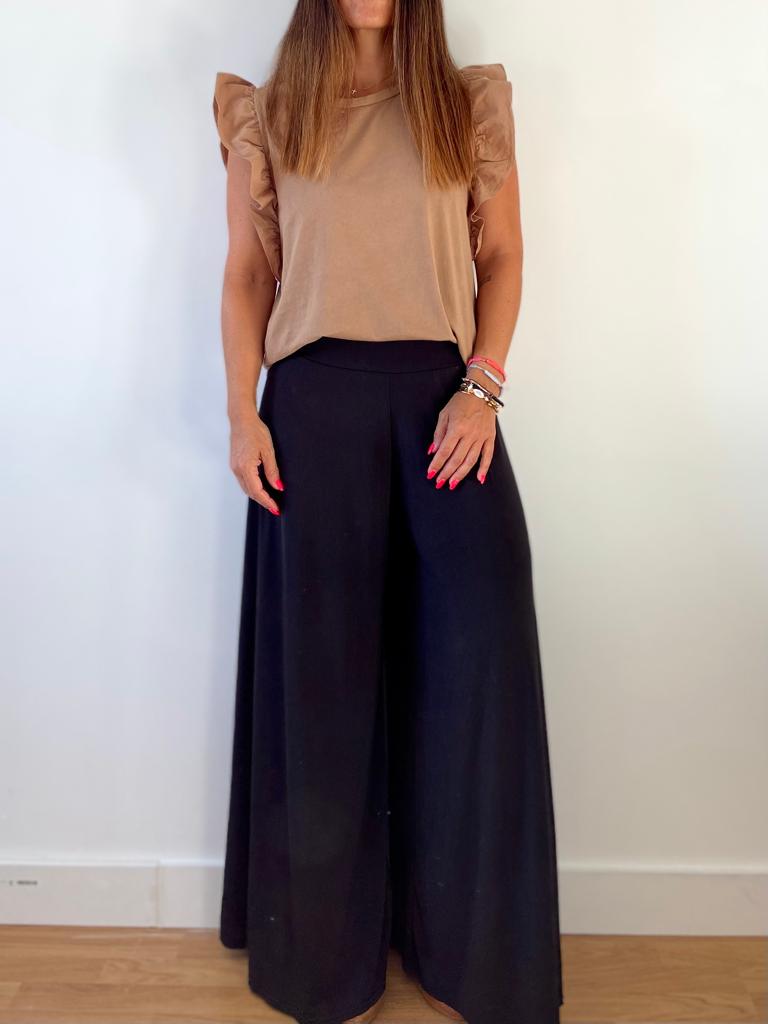 Conjunto feminino com blusa bege e calças largas pretas em fundo branco